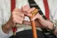 An elderly man holding his walking stick