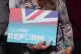 A Reform UK activist holds up a banner as party leader Nigel