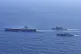 The aircraft carrier USS Carl Vinson, left, sails with South