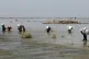 Victims of heavy flooding from monsoon rains crowd carry rel