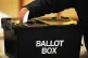 A voter placing a ballot paper in the ballot box at the poll