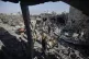 Palestinians inspect the damage of a destroyed house followi